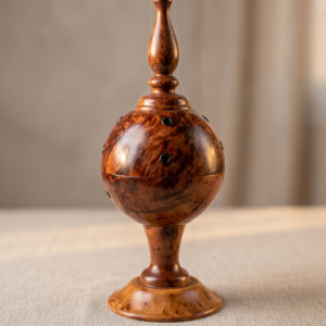 Front profile of the closed Moroccan thuya wood incense burner, showcasing the rich burl wood grain and minimalist smoke vents on a soft linen surface.